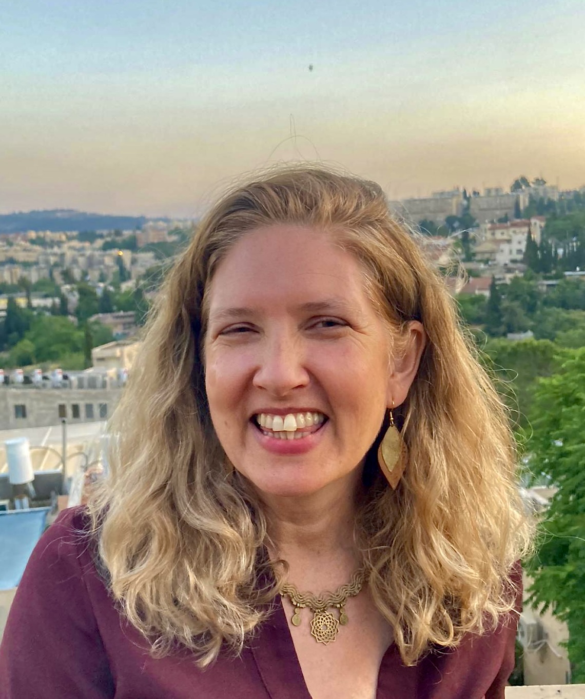 Author smiling against the back drop of a her Jerusalem Neighborhood