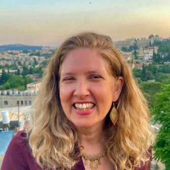 Author Amelia Weinreb smiling against the back drop of her Jerusalem Neighborhood